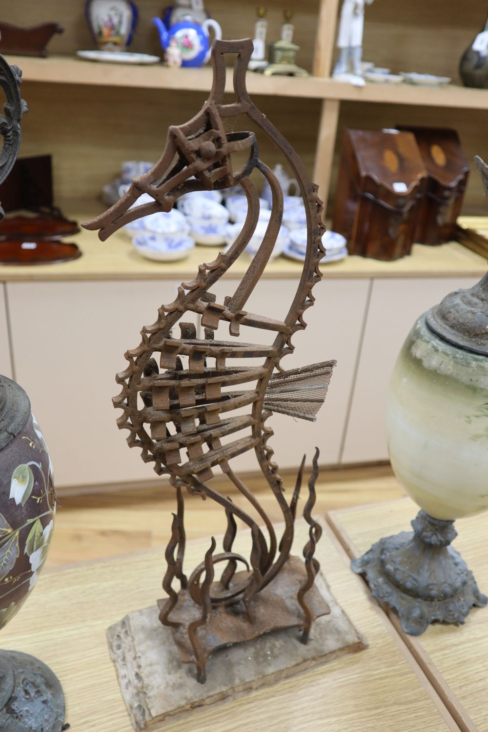 A wrought iron sea horse sculpture, 58cm and two spelter and enamelled glass ewers, 56cm